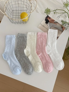 Detail of five pairs of thin hollow knit mesh crew socks in assorted pastel colors