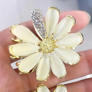 Détail de la pince à cheveux marguerite en opale avec centre doré et pétale en cristal