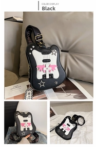 Close-up of black guitar-shaped crossbody bag with pink wing patch and studded detail