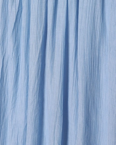 Gros plan sur le tissu plissé bleu clair montrant la texture et le drapé vertical