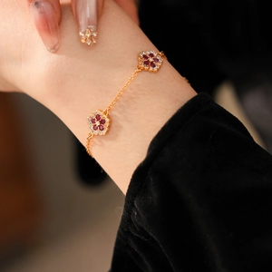 Close-up of 18k gold plated bracelet with zircon flower charms on a female wrist