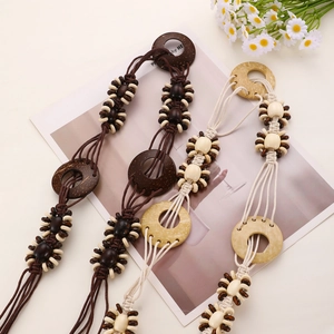 Detail of bohemian woven waist chain with wooden beads and rings in brown and ivory
