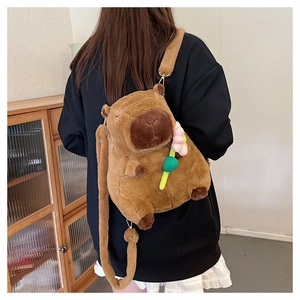 Rear view of a model wearing the brown capybara plush backpack with a pink flower detail