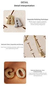 Detailed view of gold and silver letter pendants with micro-paved cubic zirconia stones