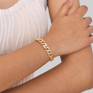 Detailansicht eines Gold-Panzerarmbands mit Zirkonia-Besatz am Handgelenk eines Models