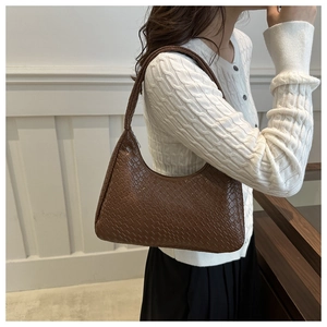 Detail of deep brown woven hobo bag showing the luxury texture and half-moon shape