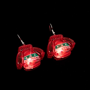 Macro shot of red LED light-up Christmas sweater earrings with silver hooks on black background