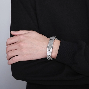 Detail of hip hop stainless steel braided chain bracelet with textured rectangular link
