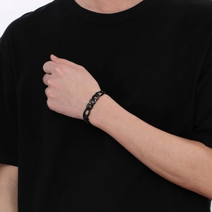 Macro shot of 9mm black stainless steel Figaro link bracelet on male model wrist