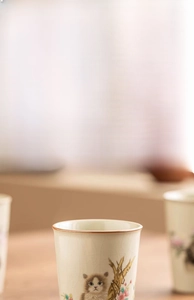 Detail of Ru Kiln ceramic teacup featuring cat and magnolia hand-painted patterns