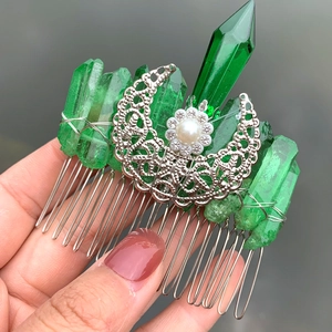 Detail of handmade silver crescent moon hair comb with green crystal and center pearl