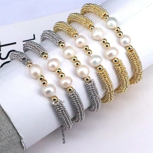 Handmade 5-piece gold and silver beaded bracelet set with white pearls on a display