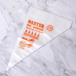 Détail d'une poche à douille jetable avec logo Master orange sur fond de marbre blanc