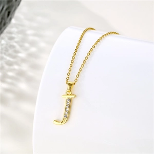 Detail shot of the golden letter J pendant necklace with zircon stones on white background