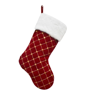 Red Christmas stocking with golden grid sequins and white faux fur trim on white background