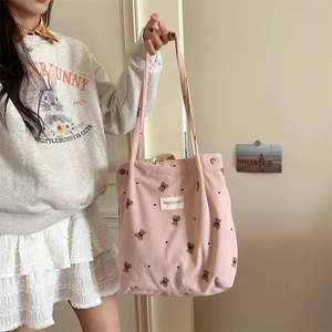 Close-up of pink corduroy tote bag featuring a cute bear print and high texture detail