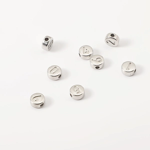 Macro-opname van zilveren roestvrijstalen kralen met cijfers 0-9 voor DIY-sieraden