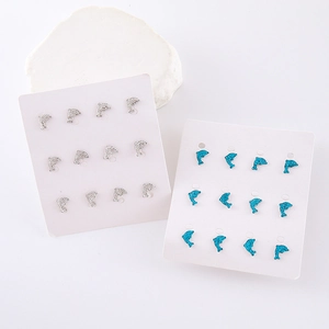 Exquisite silver and blue dolphin stud earrings set with rhinestones on white display