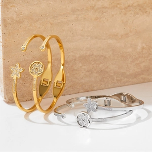 Polished stainless steel open spring bracelet with star and flower crystal charms