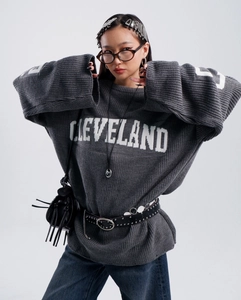 Detailed texture of gray knit sweater featuring white Cleveland jacquard lettering