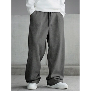 Detail of dark grey wide-leg sweatpants with drawstring waist and heavy fabric drape