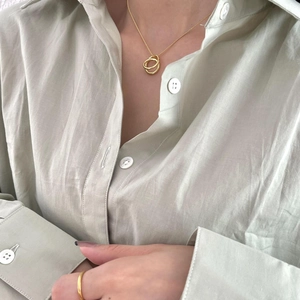 Close-up of a minimalist gold 925 silver necklace with interlocking oval rings on a model