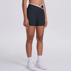 Detail of high-waist black yoga shorts featuring a V-shaped crossover waist with white piping