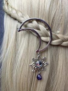 Close-up of a silver crescent moon hair clip with sun charm and purple crystal drop bead