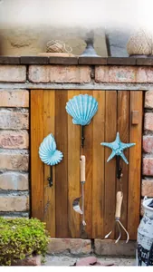 Détail de crochets coquillage et étoile de mer avec outils de jardin sur mur rustique