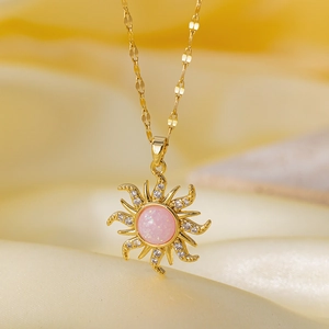 Detailed macro view of a gold sun pendant with pink gemstone and micro zircon inlays