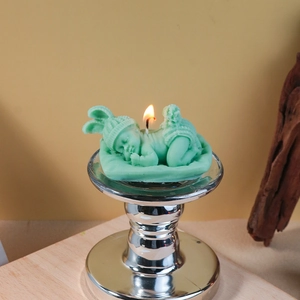 Detailed view of sleeping baby candle with rabbit ear hat and mint green texture