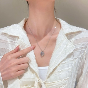 Detail of heart necklace with purple stone and 100 languages projection charm