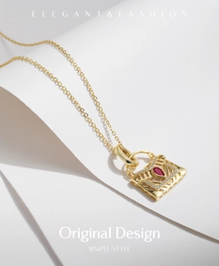 Détail du collier sac en argent s925 doré avec pierre rouge poire et petits diamants