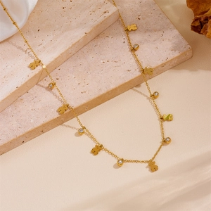 Golden bear charm necklace with sparkling round crystals on a premium stone surface