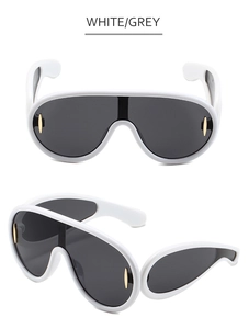 Macro shot of white oversized shield sunglasses with grey lenses and gold oval details