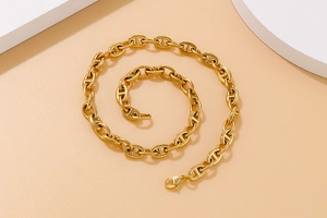 Detail of the golden anchor link chain necklace with polished oval pig nose connectors