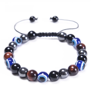 Dettaglio macro delle perle da 8mm in occhio di tigre rossa e ossidiana su bracciale intrecciato