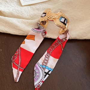 Detail of red and white silk scarf wrapped hair claw with vintage chain patterns