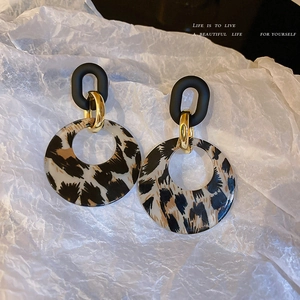 Retro geometric leopard print hoop earrings with golden links on a white paper background