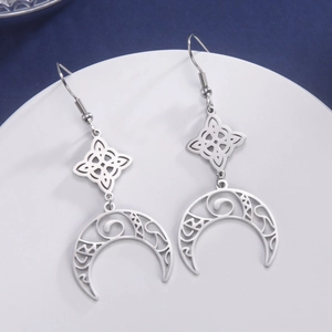 Detail of silver stainless steel earrings featuring Celtic knots and hollow moon pendants