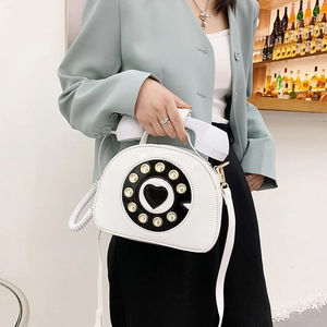 Detail of creative white patent leather crossbody bag with vintage telephone dial and handle