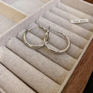 Créoles minimalistes en argent pour femmes présentées dans un écrin de luxe en velours beige