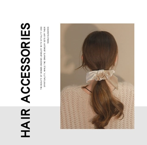 Detail view of a beige velvet bow hair scrunchie worn on model for hair styling