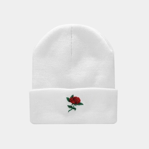 Detail of red rose embroidery on a white ribbed knit beanie for street fashion style