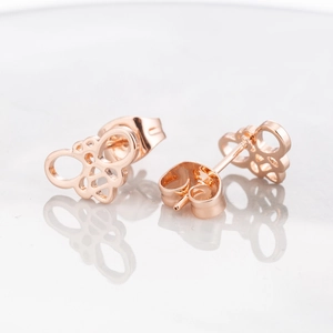 Elegant hollow bee stud earrings in rose gold finish on white reflective surface