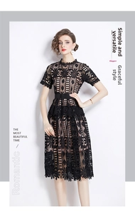 Detailed close-up of intricate hollow-out floral lace pattern on elegant black midi dress