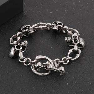 Detailed view of punk style skull link bracelet with vintage silver finish and T-bar clasp