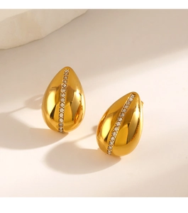 Détail macro de boucles d'oreilles goutte dorées ornées d'une rangée de zircons
