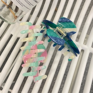 Detail of premium acetate hair claws with pink, green and blue gradient texture finish