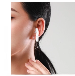 Detail of silver S925 sterling silver ear cuff with chain worn with wireless earbud